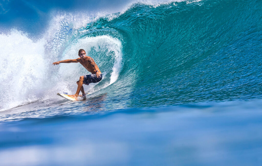 Surfer catching a wave while wearing performance board shorts